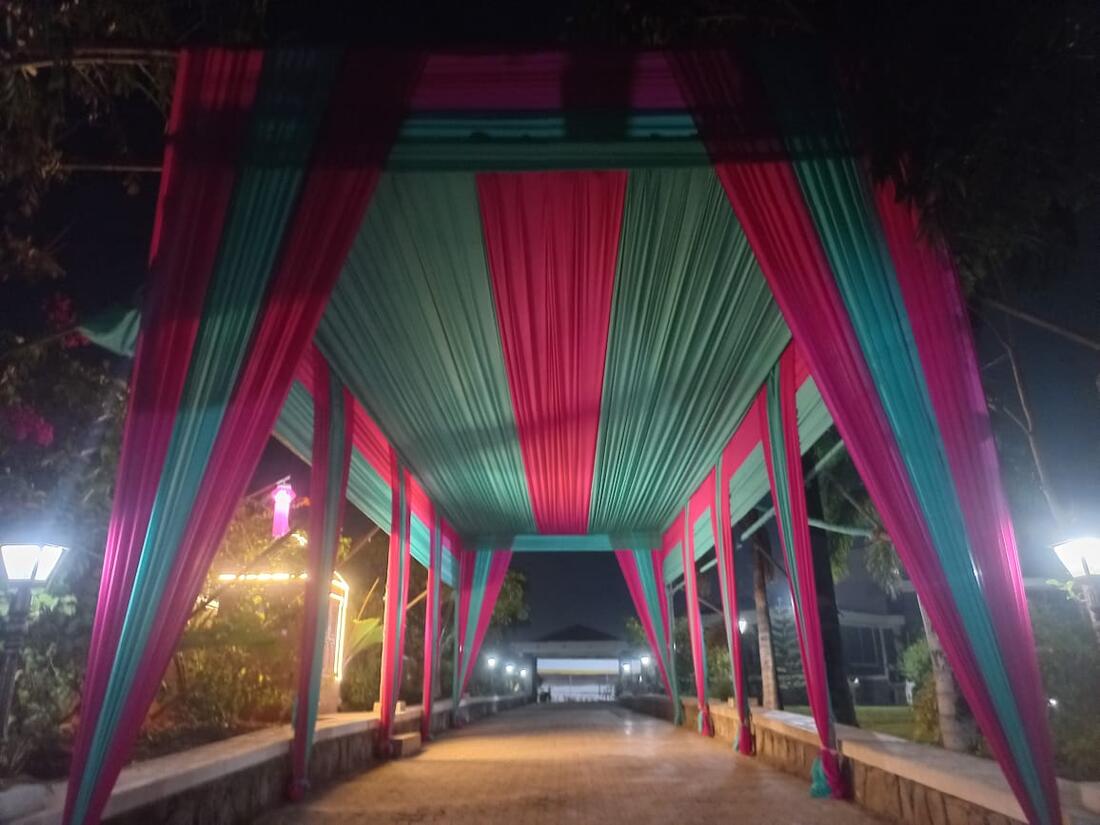 A teal and pink striped fabric canopy over an outdoor walkway